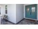 Inviting front porch with turquoise front door, light-colored siding, and brick walkway at 16511 Cornwall Ln, Lakewood Ranch, FL 34202