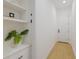 Hallway with hardwood floors, built in shelves, neutral wall color, and modern lighting at 16511 Cornwall Ln, Lakewood Ranch, FL 34202