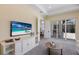 Bright living room with built-in shelves, TV, and sliding glass doors to outside at 16511 Cornwall Ln, Lakewood Ranch, FL 34202
