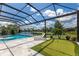 Screened-in pool area with putting green, lounge chairs, and beautiful lake view at 16511 Cornwall Ln, Lakewood Ranch, FL 34202