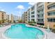 A large outdoor pool with lounge chairs, surrounded by modern condo buildings under a sunny sky at 1709 N Tamiami Trail # Ph 514, Sarasota, FL 34234