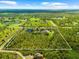 An aerial perspective highlights this expansive acreage with mature trees, a serene pond, and manicured landscaping at 21705 67Th E Ave, Bradenton, FL 34211