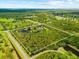 This aerial view shows the beautiful property surrounded by lush greenery and featuring a tranquil pond at 21705 67Th E Ave, Bradenton, FL 34211