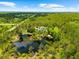 An aerial view showcases the expansive property with a serene pond, lush greenery, and surrounding natural beauty at 21705 67Th E Ave, Bradenton, FL 34211