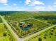 An aerial view showcases the expansive property, outlined in white, with a private pond and lush tree coverage at 21705 67Th E Ave, Bradenton, FL 34211