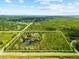 An aerial view of the acreage shows a beautiful property with a pond and abundant trees, outlined in white at 21705 67Th E Ave, Bradenton, FL 34211