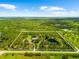 An aerial view of the property with lush green trees, a tranquil pond, and a defined boundary at 21705 67Th E Ave, Bradenton, FL 34211