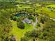 Scenic aerial shot showcasing a beautiful home nestled beside a picturesque pond with lush greenery at 21705 67Th E Ave, Bradenton, FL 34211
