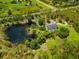 Expansive aerial view of a private estate featuring a large pond, lush landscaping, and a well-maintained residence at 21705 67Th E Ave, Bradenton, FL 34211