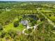 Captivating aerial perspective of a residence surrounded by a tranquil pond and verdant landscape at 21705 67Th E Ave, Bradenton, FL 34211