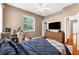 Cozy bedroom featuring ample lighting, a gaming desk, hardwood flooring, and a ceiling fan at 21705 67Th E Ave, Bradenton, FL 34211