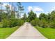Long private driveway surrounded by lush landscaping, enhancing the property's curb appeal at 21705 67Th E Ave, Bradenton, FL 34211