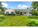 Charming single-story home with a lush green lawn, columns, and well-manicured landscaping at 21705 67Th E Ave, Bradenton, FL 34211