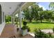 Inviting front porch with brick floor and white columns, offering picturesque views of the expansive lawn at 21705 67Th E Ave, Bradenton, FL 34211