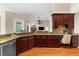 Open kitchen with granite countertops, wood cabinets, and view of fireplace at 21705 67Th E Ave, Bradenton, FL 34211