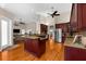 Open-concept kitchen boasts cherry cabinets, granite countertops, stainless steel appliances, and hardwood flooring at 21705 67Th E Ave, Bradenton, FL 34211