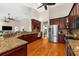Open-concept kitchen boasts cherry cabinets, granite countertops, stainless steel appliances, and hardwood flooring at 21705 67Th E Ave, Bradenton, FL 34211