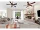 Spacious living room featuring a brick fireplace, ceiling fans, and sliding glass doors to the outdoor area at 21705 67Th E Ave, Bradenton, FL 34211