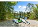 Three kayaks sit on the banks of a tranquil pond surrounded by lush greenery at 21705 67Th E Ave, Bradenton, FL 34211