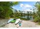 Three kayaks are resting lakeside next to a calm pond surrounded by trees at 21705 67Th E Ave, Bradenton, FL 34211