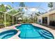 A sparkling screened-in pool features a connected spa and a beautiful travertine deck at 21705 67Th E Ave, Bradenton, FL 34211