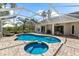 An outdoor pool area features travertine pavers and lounge furniture for relaxing at 21705 67Th E Ave, Bradenton, FL 34211