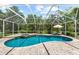 Large screened pool area featuring a spa, lounge chairs and tropical landscaping at 21705 67Th E Ave, Bradenton, FL 34211