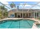 An in-ground pool is enclosed with a screen and surrounded by a brick patio at 21705 67Th E Ave, Bradenton, FL 34211