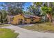 Rear exterior of home with damaged roof, showcasing a large concrete driveway and a detached structure at 218 32Nd W St, Bradenton, FL 34205