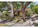 Cozy yellow home featuring shade trees, a brick walkway, and lush landscaping at 218 32Nd W St, Bradenton, FL 34205