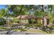 Quaint yellow home with mature trees, a well-kept lawn, and a welcoming entrance at 218 32Nd W St, Bradenton, FL 34205