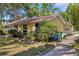 Cozy single-story home with mature trees and shrubs and a brick walkway leading to the front entrance at 218 32Nd W St, Bradenton, FL 34205