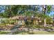 Inviting single-story home featuring a yellow exterior, white trim, and mature landscaping in a serene setting at 218 32Nd W St, Bradenton, FL 34205