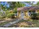 Charming yellow single-story home with a well-maintained lawn, mature trees, and a welcoming front entrance at 218 32Nd W St, Bradenton, FL 34205