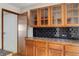 Kitchen showcasing wooden cabinets with glass inserts and black subway tile backsplash at 218 32Nd W St, Bradenton, FL 34205