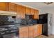 Functional kitchen featuring oak cabinets, black appliances, and dark backsplash at 218 32Nd W St, Bradenton, FL 34205