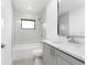 Bathroom with a modern vanity, a framed mirror, and a tub with a shower-head and gray marble-look tiling at 234 Antofagasta St, Punta Gorda, FL 33983