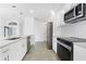 Modern kitchen boasts white cabinets, stainless appliances, and elegant pendant lighting at 234 Antofagasta St, Punta Gorda, FL 33983