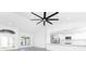 Open concept living room with large ceiling fan and an adjacent kitchen with white cabinetry at 234 Antofagasta St, Punta Gorda, FL 33983