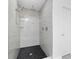 A walk-in shower with rain shower head, glass shelving, white marble surround, and black stone floor at 234 Antofagasta St, Punta Gorda, FL 33983
