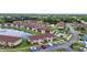 Aerial view of a condo community featuring a tranquil pond, pool, and parking at 25100 Sandhill Blvd # V202, Punta Gorda, FL 33983