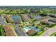 Aerial view showcasing community amenities, including pool, tennis courts, and a beautiful pond at 25100 Sandhill Blvd # V202, Punta Gorda, FL 33983
