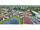 An aerial view of the community showcasing pools, tennis courts, parking, and beautifully maintained landscaping at 25100 Sandhill Blvd # V202, Punta Gorda, FL 33983