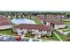 Aerial view of condominium community featuring a peaceful pond with fountain and walkways at 25100 Sandhill Blvd # V202, Punta Gorda, FL 33983