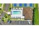 Aerial view of pool and tennis courts featuring lounge chairs, parking, and mature tropical landscaping around the community at 25100 Sandhill Blvd # V202, Punta Gorda, FL 33983