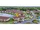 Scenic aerial view of a condo community with lush landscaping, lake, swimming pool, and tennis courts at 25100 Sandhill Blvd # V202, Punta Gorda, FL 33983