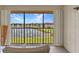 Balcony with seating offers a serene view of the lush landscaping and the lake at 25100 Sandhill Blvd # V202, Punta Gorda, FL 33983