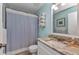 Cozy bathroom with granite countertop, convenient towel rack, and blue shower curtain at 25100 Sandhill Blvd # V202, Punta Gorda, FL 33983
