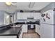 Kitchen with stainless steel appliances, a breakfast bar, white cabinets, and tile flooring at 25100 Sandhill Blvd # V202, Punta Gorda, FL 33983