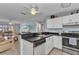 Well-lit kitchen with a functional breakfast bar, stainless steel appliances, and adjacent living area at 25100 Sandhill Blvd # V202, Punta Gorda, FL 33983